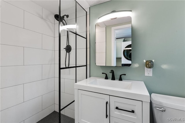 bathroom featuring stacked washer and dryer, vanity, and toilet