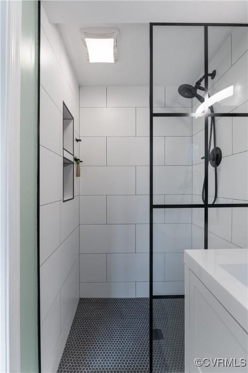 bathroom featuring a tile shower and vanity