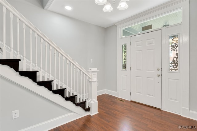 foyer entrance featuring dark wood-type flooring and an inviting chandelier