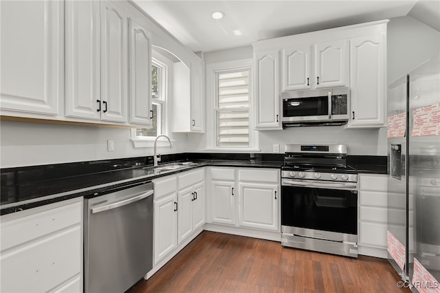 kitchen with white cabinetry, appliances with stainless steel finishes, sink, and dark wood-type flooring