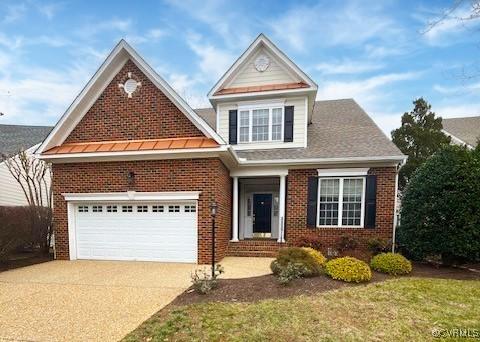 traditional-style home with driveway, a garage, and brick siding