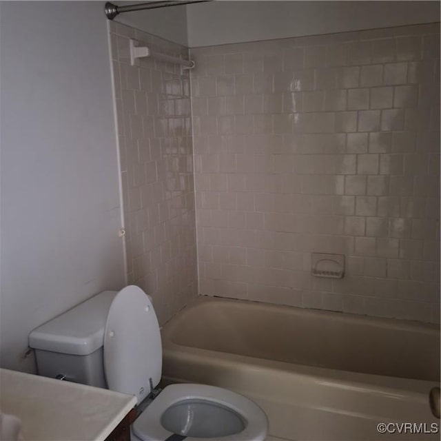 bathroom featuring tiled shower / bath combo and toilet