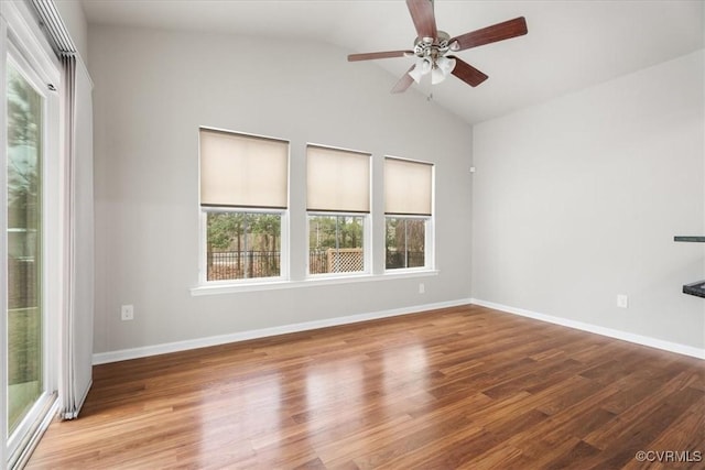 empty room with hardwood / wood-style flooring, ceiling fan, and vaulted ceiling