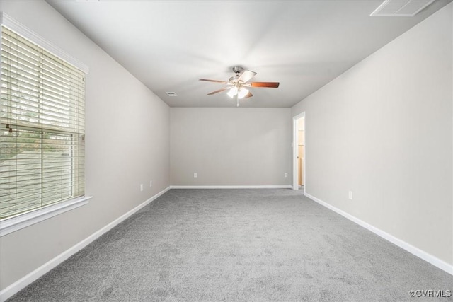 carpeted spare room featuring ceiling fan