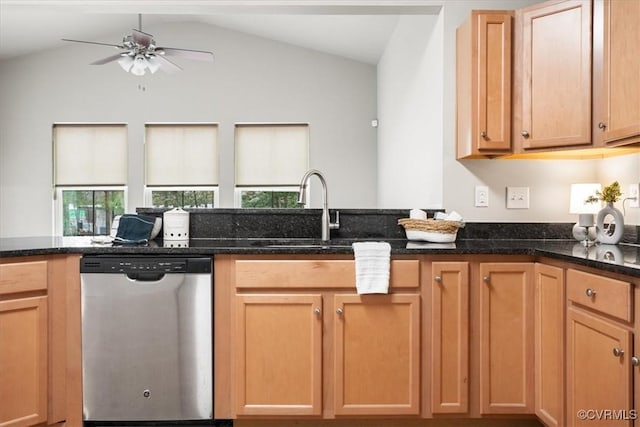 kitchen featuring lofted ceiling, dark stone counters, dishwasher, and sink