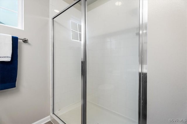 bathroom featuring a shower with door