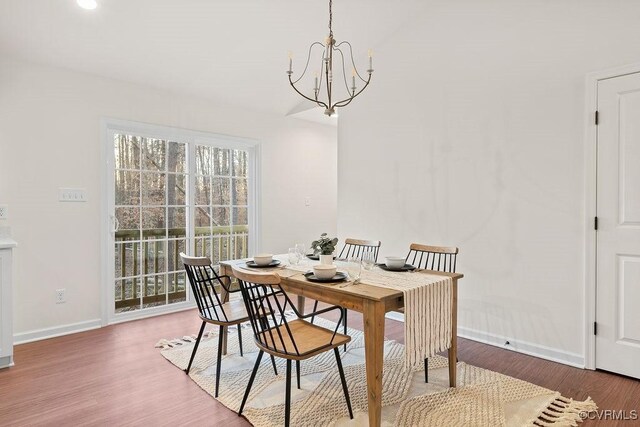 dining room with hardwood / wood-style flooring and a notable chandelier