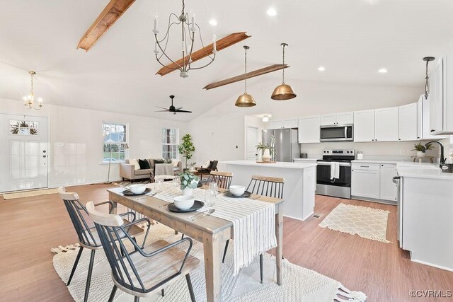 dining room with sink, light hardwood / wood-style flooring, beam ceiling, high vaulted ceiling, and ceiling fan with notable chandelier