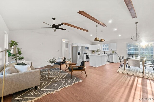 living room featuring sink, high vaulted ceiling, ceiling fan, and light wood-type flooring