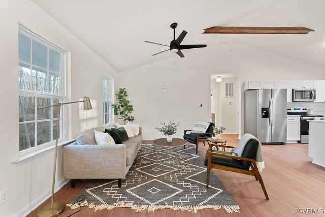 living room featuring wood-type flooring, vaulted ceiling, and ceiling fan