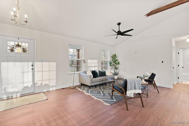 living room with hardwood / wood-style flooring, vaulted ceiling, and ceiling fan with notable chandelier