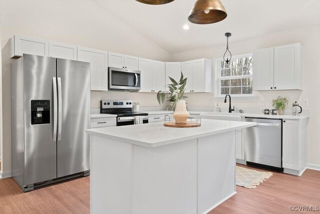 kitchen with white cabinetry, a center island, appliances with stainless steel finishes, and sink