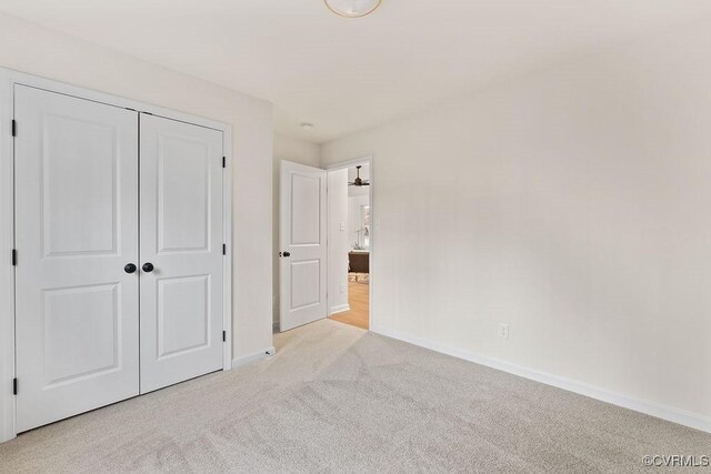 unfurnished bedroom featuring a closet and light carpet