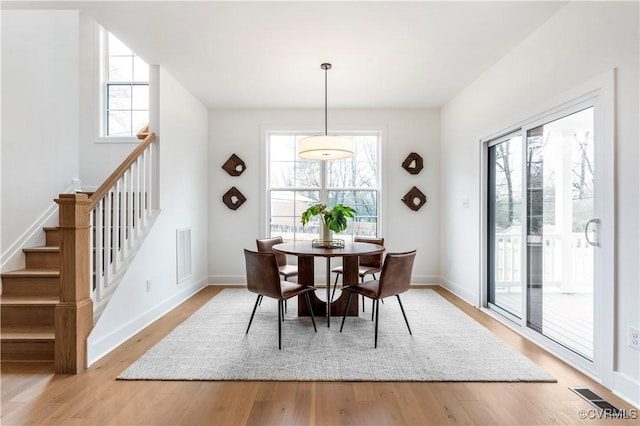 dining room with plenty of natural light and light hardwood / wood-style flooring