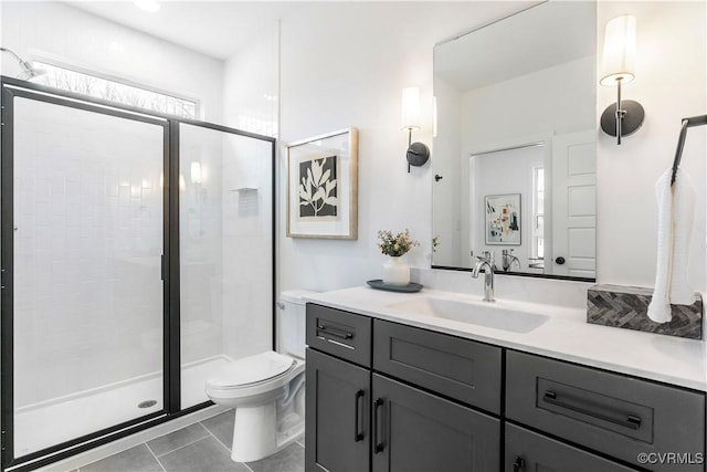 bathroom with tile patterned floors, vanity, toilet, and a shower with shower door