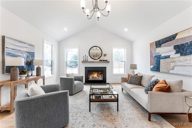 living room featuring lofted ceiling, hardwood / wood-style floors, and an inviting chandelier