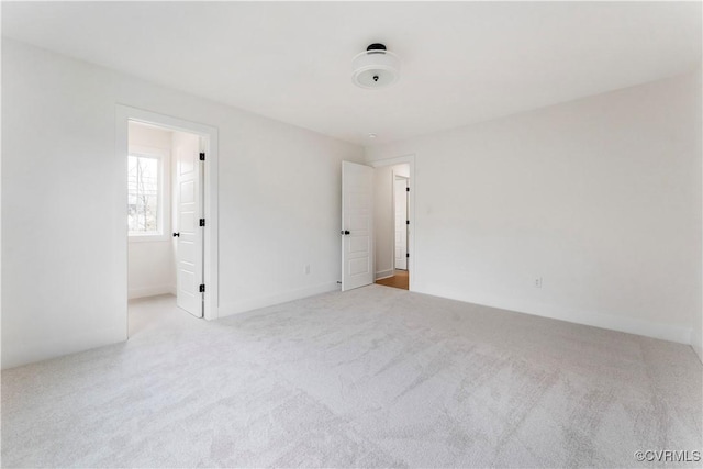 unfurnished room featuring light colored carpet