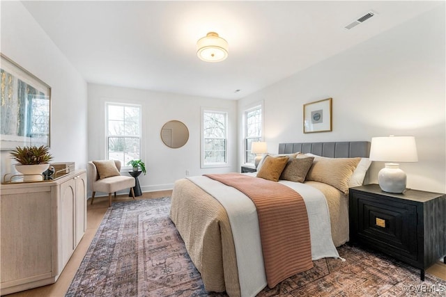 bedroom with wood-type flooring and multiple windows