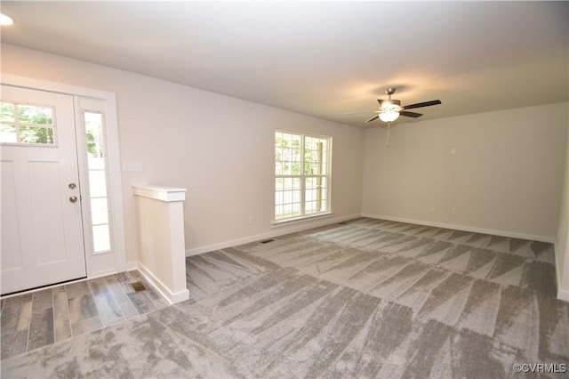 entryway featuring ceiling fan and carpet