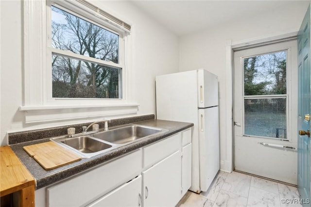 kitchen with sink, white cabinets, and white refrigerator