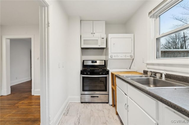 kitchen featuring gas stove, sink, and white cabinets