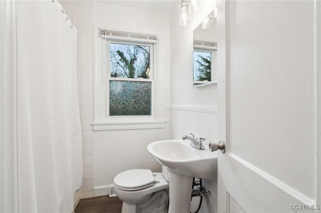 bathroom with a shower with curtain, toilet, and hardwood / wood-style flooring