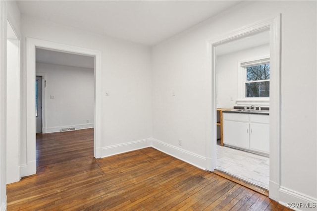 unfurnished room with dark wood-type flooring and sink