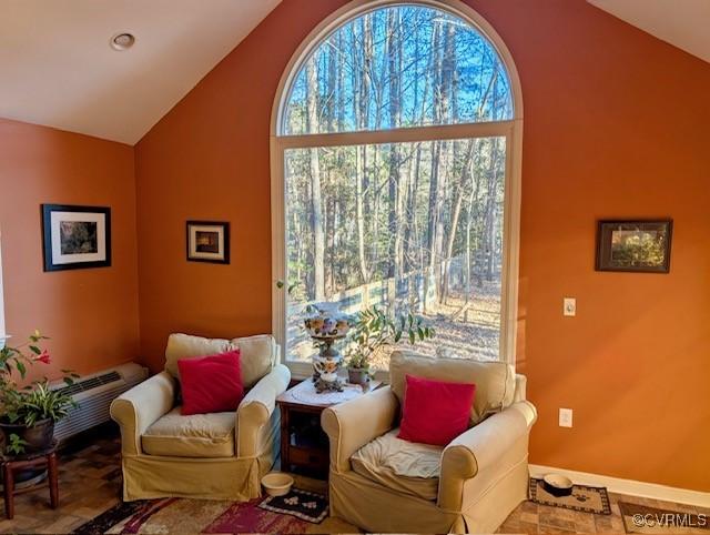 sitting room with high vaulted ceiling and an AC wall unit