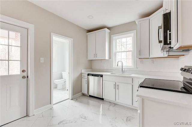 kitchen with backsplash, stainless steel appliances, sink, and white cabinets