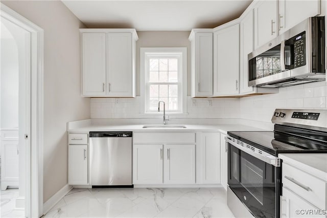 kitchen with appliances with stainless steel finishes, sink, white cabinets, and backsplash