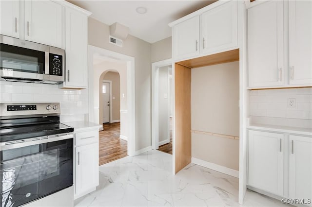 kitchen featuring appliances with stainless steel finishes, decorative backsplash, and white cabinets