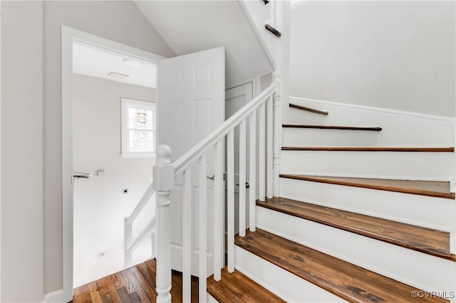 stairway with lofted ceiling and wood-type flooring