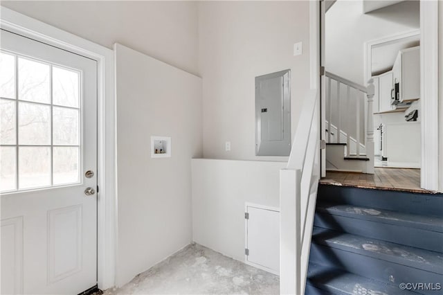 staircase featuring concrete flooring and electric panel