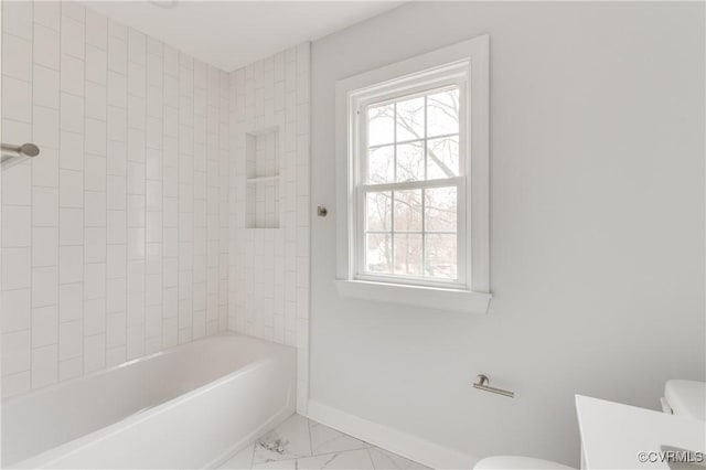 bathroom featuring tiled shower / bath and toilet