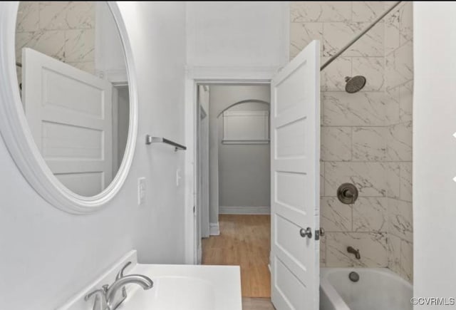 bathroom featuring tiled shower / bath, wood-type flooring, and sink