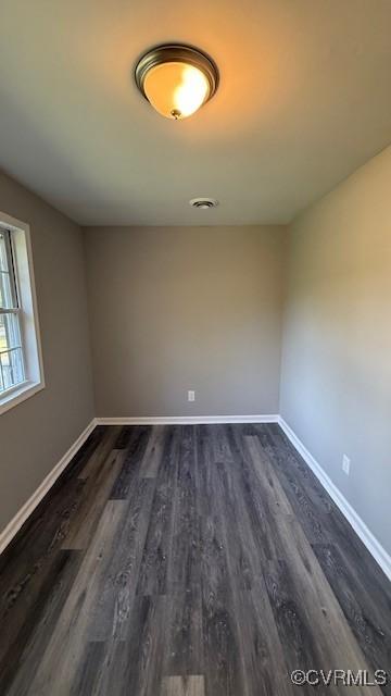 unfurnished room with dark hardwood / wood-style flooring