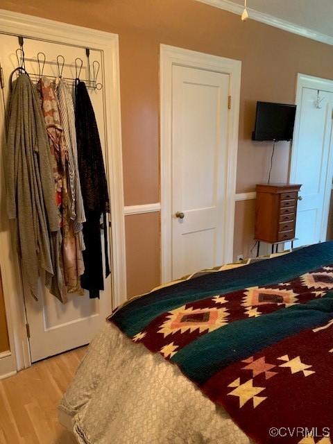 bedroom featuring hardwood / wood-style flooring and crown molding