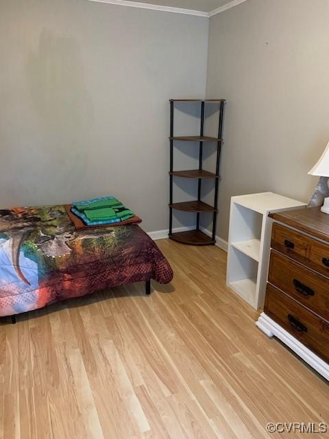 bedroom featuring crown molding and light hardwood / wood-style flooring