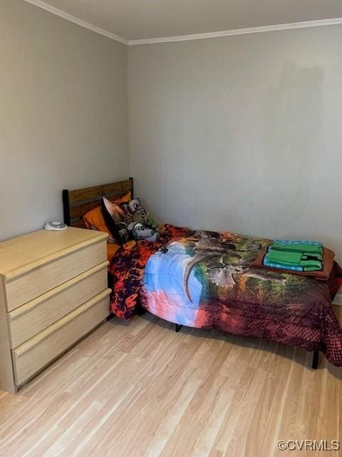 bedroom featuring crown molding and light wood-type flooring