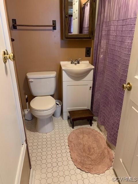 bathroom with vanity, toilet, and curtained shower