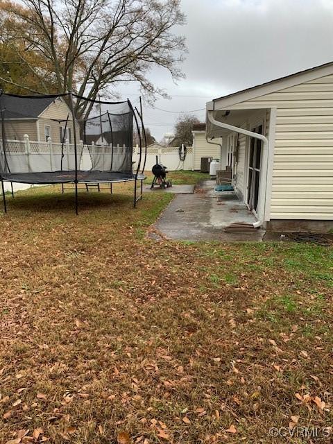 view of yard featuring a trampoline and a patio area