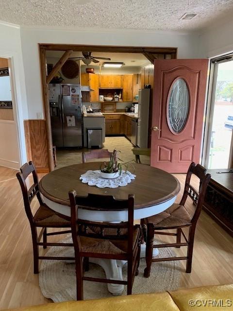 dining room featuring ceiling fan, a textured ceiling, and light hardwood / wood-style flooring