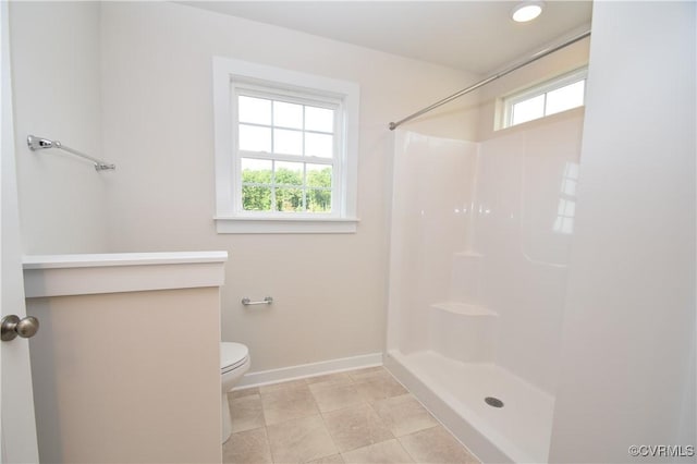 bathroom featuring a healthy amount of sunlight, toilet, and a shower