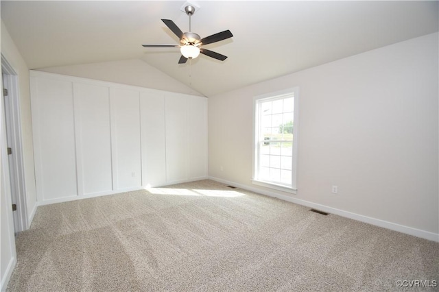 unfurnished bedroom with ceiling fan, lofted ceiling, and light carpet