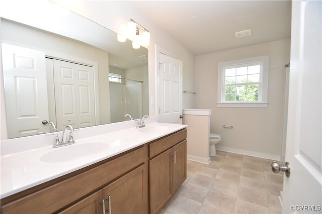 bathroom with vanity, tile patterned flooring, toilet, and walk in shower