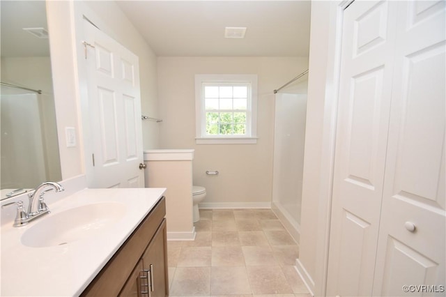 bathroom with vanity, toilet, and a shower