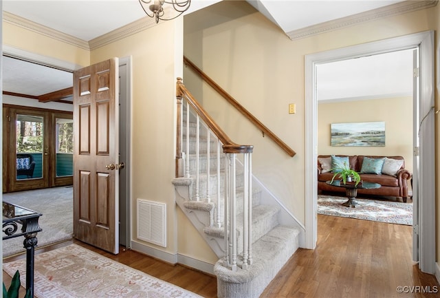 stairs with hardwood / wood-style flooring and ornamental molding