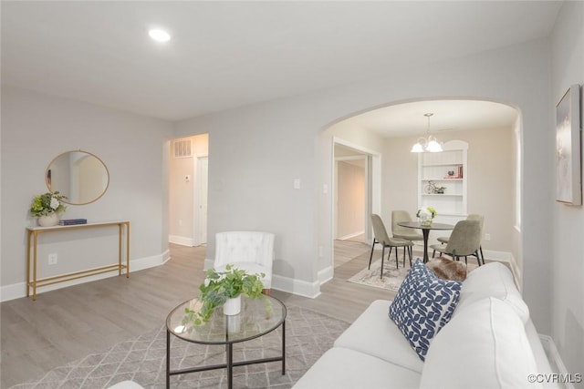 living room featuring an inviting chandelier and light hardwood / wood-style flooring