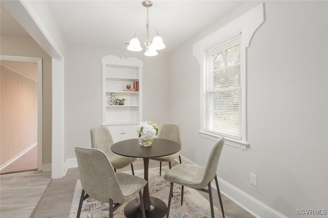 dining space featuring an inviting chandelier and light wood-type flooring