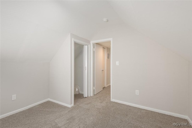 additional living space featuring vaulted ceiling and light carpet